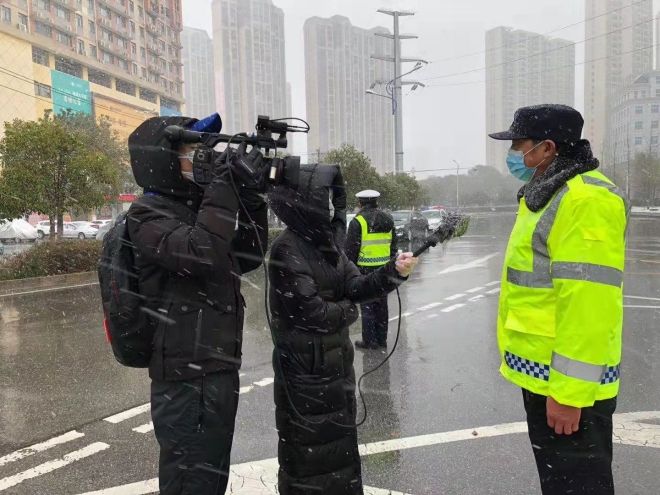 孝感市融媒體中心楊亞玲（風(fēng)雪中，采訪疫情期間重返一線的退休警察）_副本.jpg.jpg